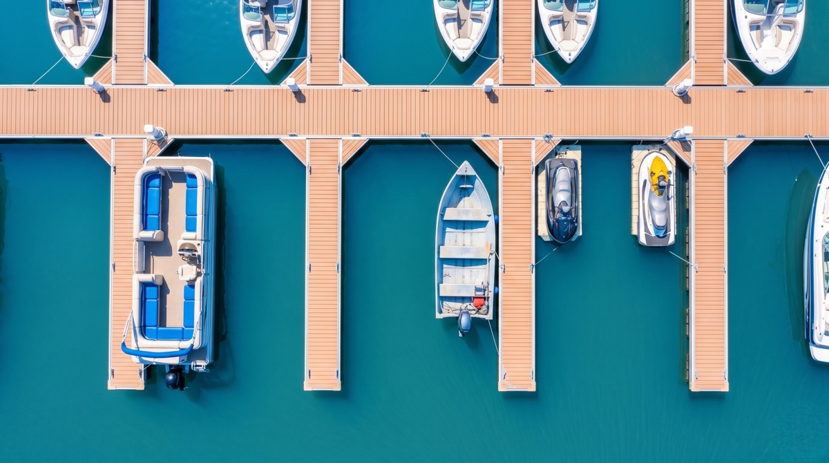 Boat rental pricing board and pontoon boats at a lake marina